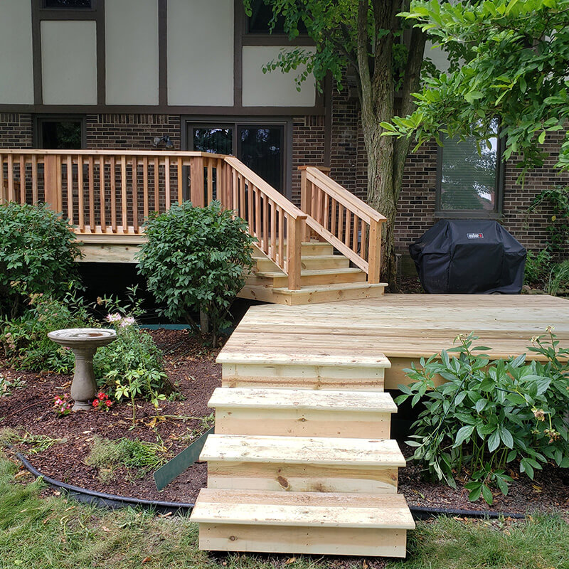 Custom Wooden Deck Addition with Stairs around Shrubbery
